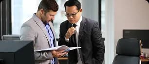 Two businessmen examining documents in a professional meeting